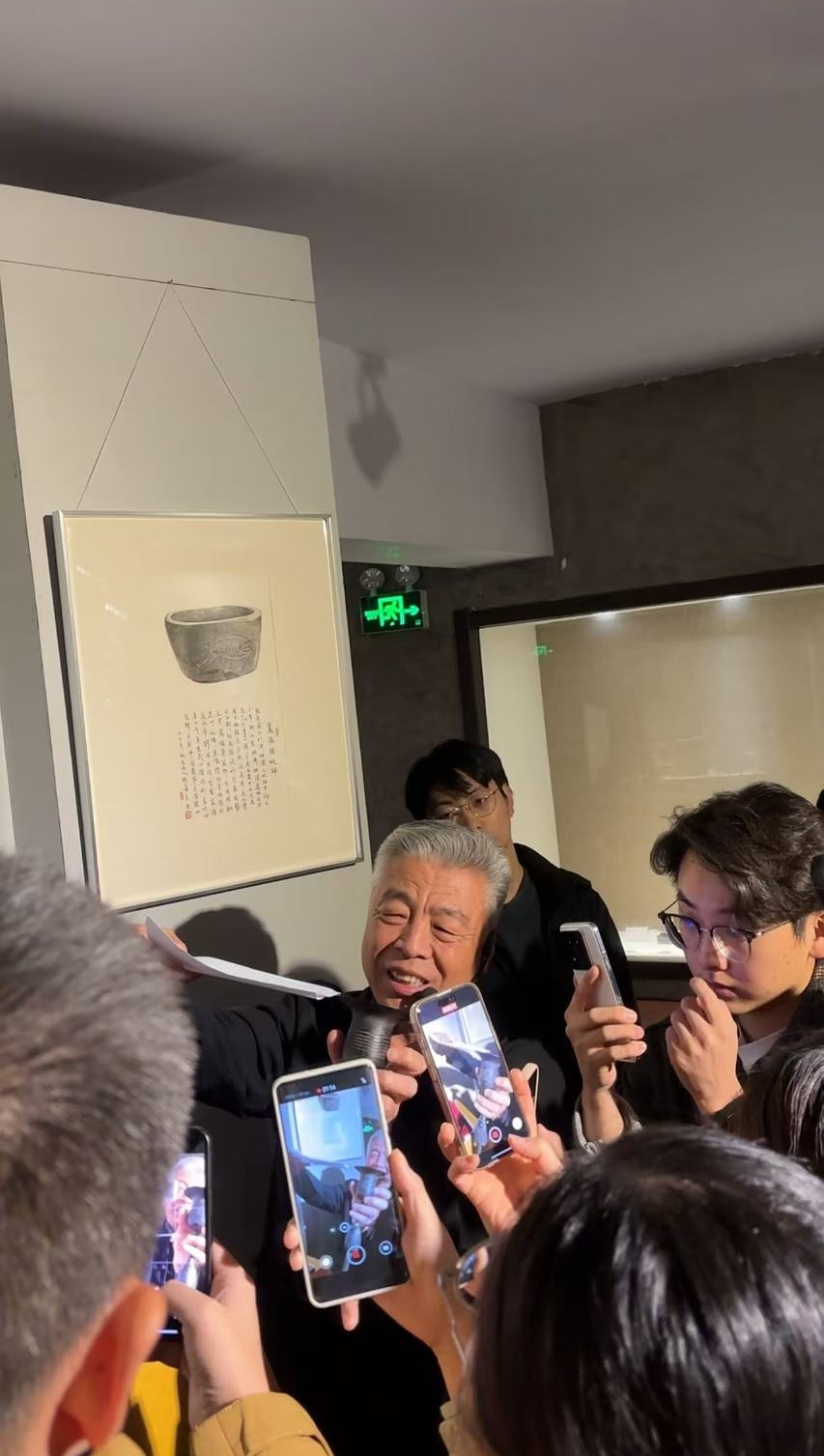黑陶邢文化博物館館長邢葆東展示兩張相疊的A4紙，向記者解釋此為杯口的厚度。