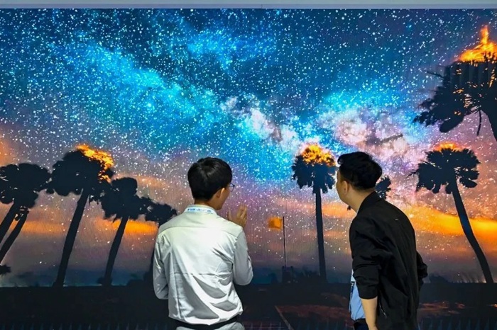 長春光博會希達電子展區(qū)，一位工作人員正在給一位觀眾講解。（長春新區(qū)供圖）