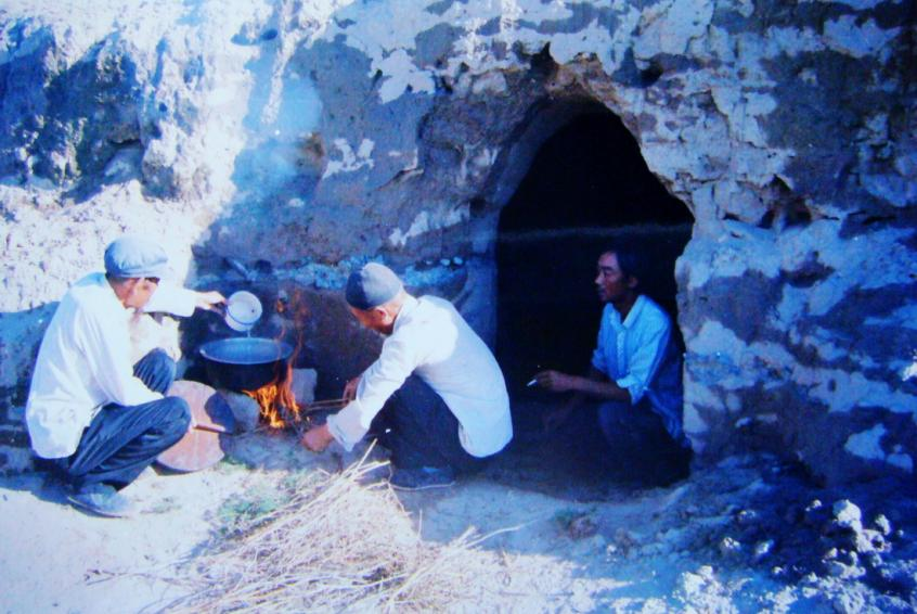 1983年，“六老漢”一代治沙人在“地窩子”生活做飯。新華社發(fā)（八步沙林場供圖）