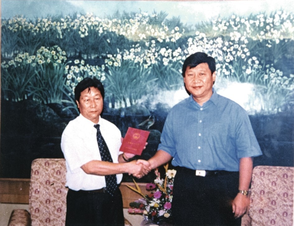 2000年7月，習近平為福建農(nóng)林大學教授林占熺頒發(fā)福建省政府“一等功”榮譽證書。圖源：《習近平在福建》（下）