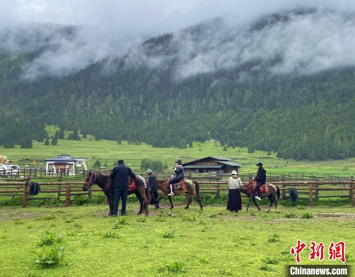 6月10日，游客在魯朗小鎮(zhèn)高山牧場(chǎng)景區(qū)體驗(yàn)騎馬。　冉文娟 攝