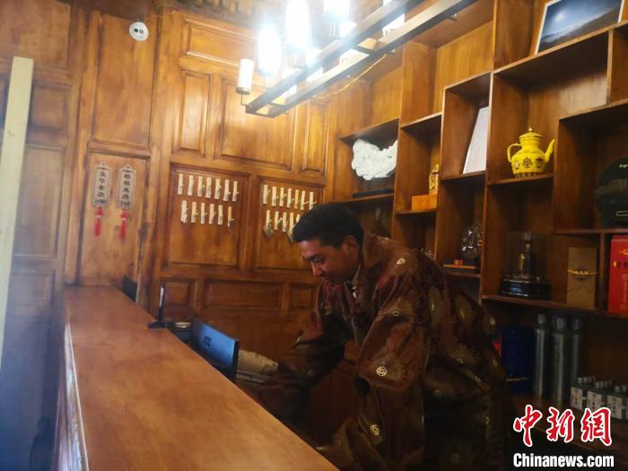 圖為桑杰才讓用電腦處理財務(wù)?！∈缝o靜 攝