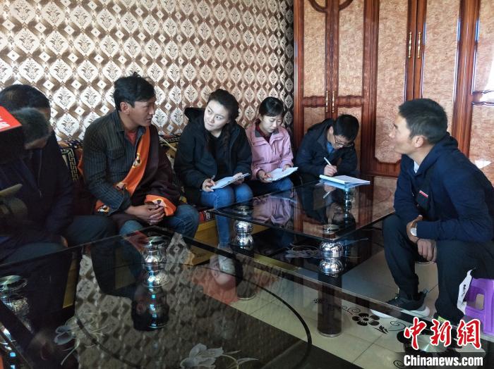 圖為調(diào)查組工作人員正在入戶調(diào)查?！∑钤鲚?攝