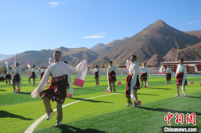 圖為青海師范大學(xué)附屬玉樹實驗學(xué)校學(xué)生在綠茵場跳起囊謙古舞—卓根瑪?！〕逃?攝