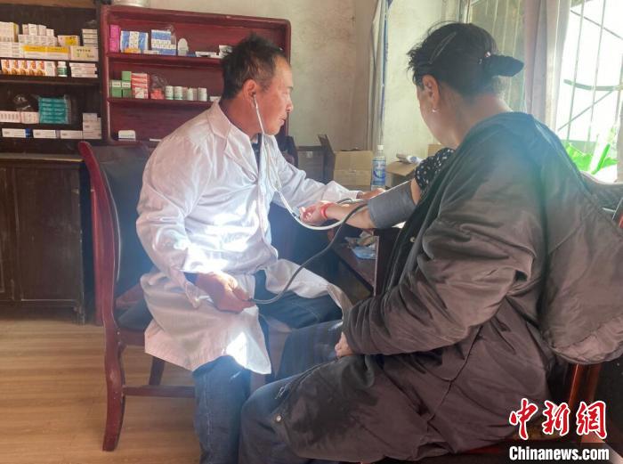 索木滾(左)為村民看病。　壤塘縣委宣傳部供圖