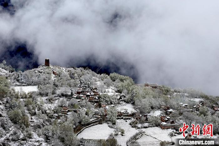 雪后的藏寨和碉樓構成美麗的雪景?！〗党鯘衫?攝