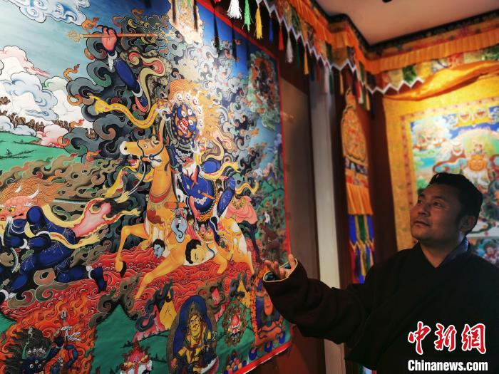 圖為久美尖措展示唐卡作品。　張?zhí)砀?攝
