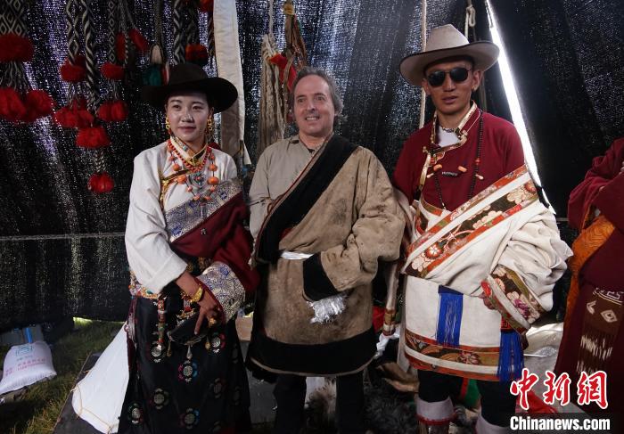 圖為一名外籍攝影師(中)身穿藏服和藏族民眾合影留念?！●R銘言 攝