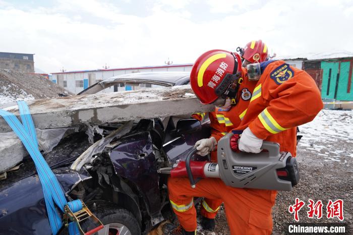 圖為地震實戰(zhàn)拉動現(xiàn)場，參演人員進行車輛破拆?！∮駱湎拦﹫D