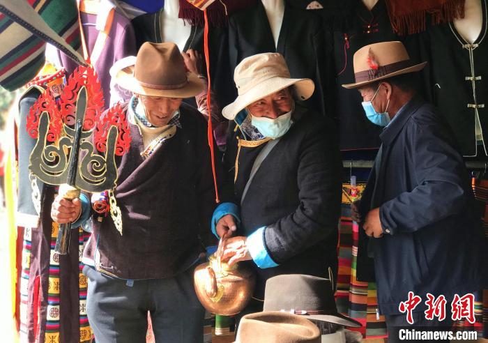 圖為三位藏族老人在集市上聊天交談?！∪轿木?攝
