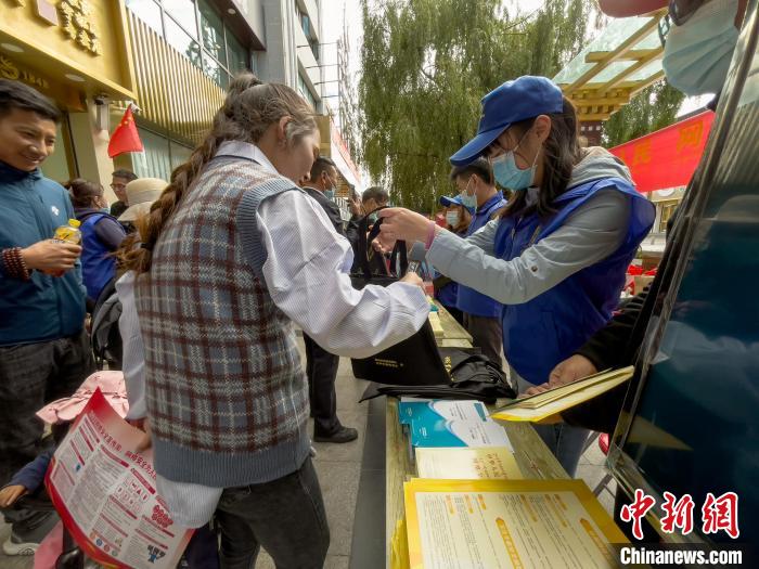 圖為志愿者為市民發(fā)放網(wǎng)絡(luò)安全宣傳手冊(cè)?！≈x牧 攝
