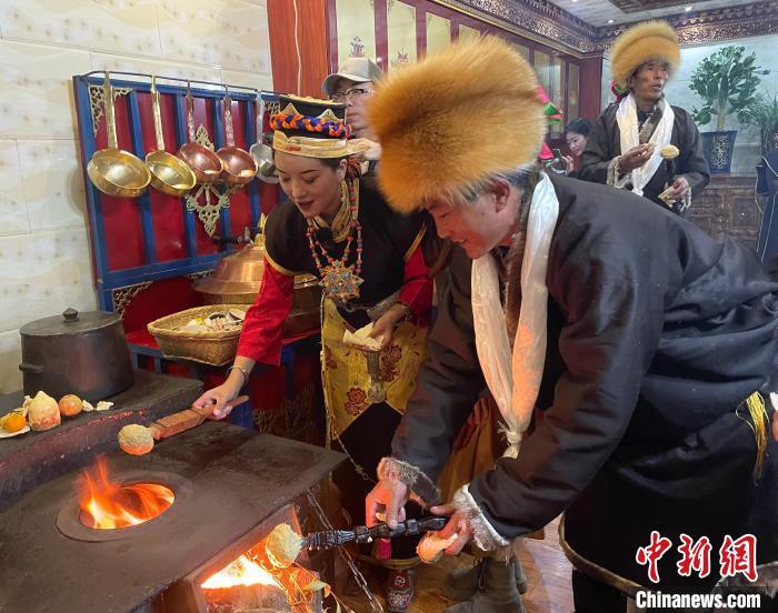 圖為人們在火上烤節(jié)日美食“結(jié)達”?！∪轿木?攝
