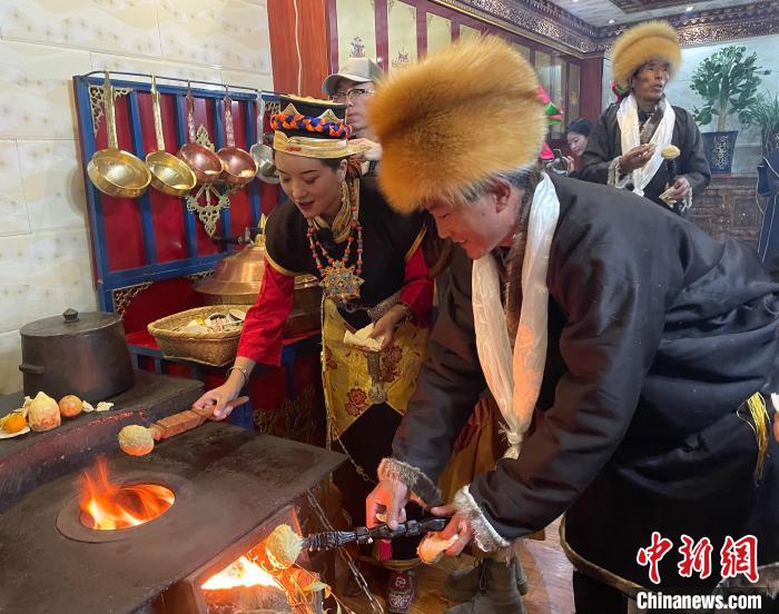 圖為人們?cè)诨鹕峡竟?jié)日美食“結(jié)達(dá)”?！∪轿木?攝