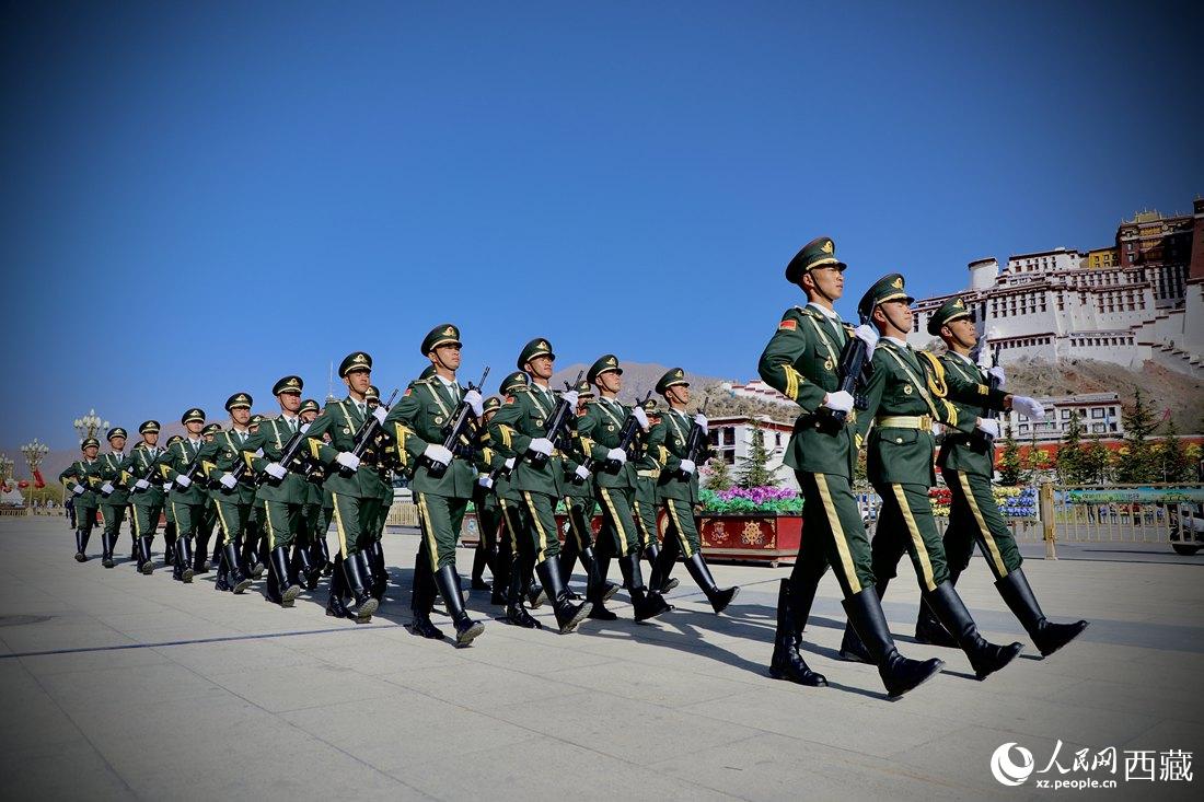 國旗護(hù)衛(wèi)隊(duì)隊(duì)員緊握鋼槍，踏著威武雄壯的步伐，走向國旗臺(tái)。人民網(wǎng) 次仁羅布攝