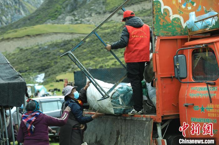 圖為工作人員幫助牧民們卸家具?！÷蹇?攝