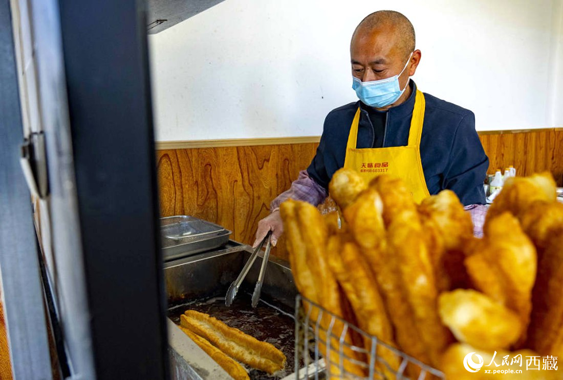 早餐店老板正在炸油條。人民網(wǎng) 次仁羅布攝