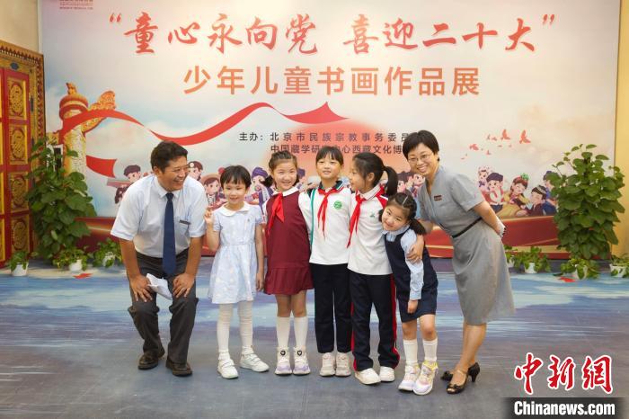 圖為與會嘉賓與入選畫作的“小作者”們在展覽上合影?！≈袊貙W(xué)研究中心供圖