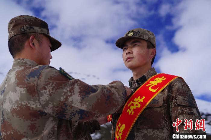 排長(zhǎng)王朝偉(圖左)給退伍老兵佩戴大紅花?！∥鞑厣侥宪姺謪^(qū)某團(tuán)供圖