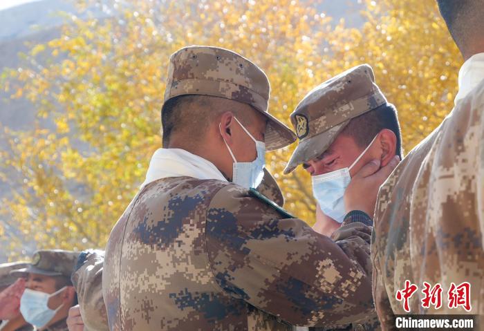 圖為什布奇邊防連退伍老兵與戰(zhàn)友相擁而泣，依依惜別?！⌒觳?攝