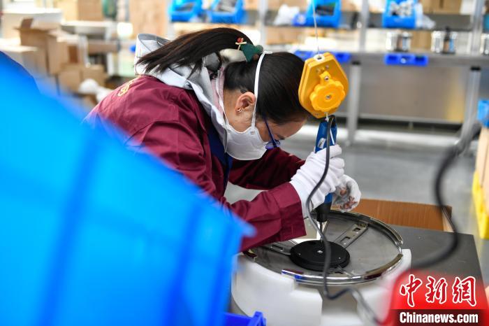 圖為工人正在組裝炊具。　貢嘎來(lái)松 攝