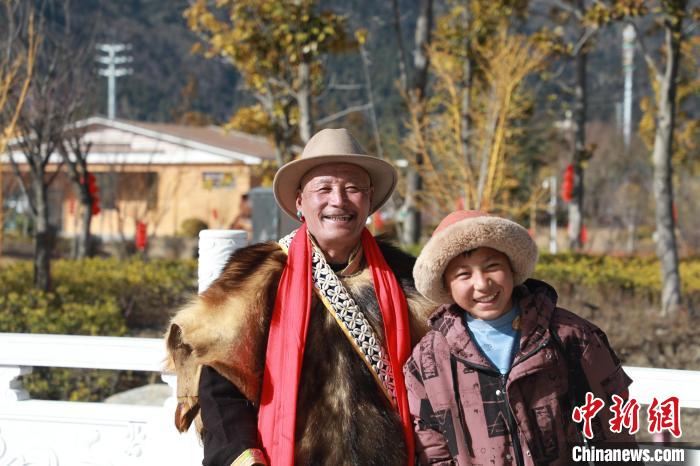 圖為林芝市巴宜區(qū)布久鄉(xiāng)仲果村村民桑杰與孫子一起參加藏歷新年活動?！埩?攝