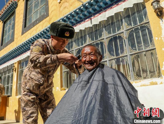 圖為阿里軍分區(qū)某邊防團(tuán)官兵為駐地群眾理發(fā)迎藏歷新年?！〉┰鰝愔?攝