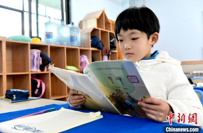 3月14日，西藏拉薩市第一小學一年級六班學生丁增樂吉在閱讀藏語課本。　李林 攝