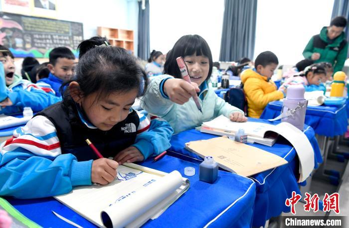 3月14日，西藏拉薩市第一小學一年級六班學生白瑪朗珍(圖左)在藏語文課上書寫藏文?！±盍?攝