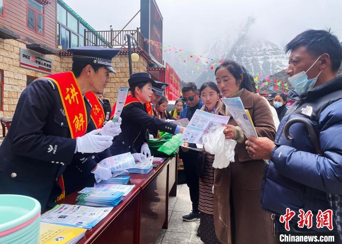 圖為山南玉麥邊境派出所民警為轄區(qū)群眾發(fā)放法律知識宣傳單?！＄婗?　攝