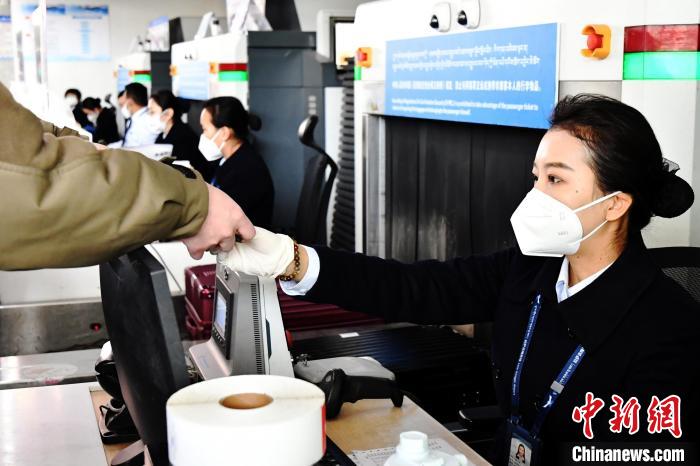 圖為機場工作人員為旅客辦理行李托運?！≈芎?攝