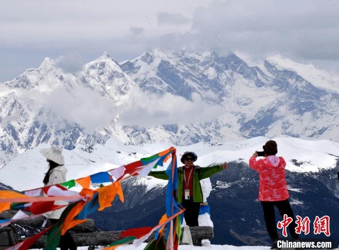 圖為5月14日，西藏林芝色季拉山觀景臺(tái)，游客與南迦巴瓦峰合影?！±盍?攝
