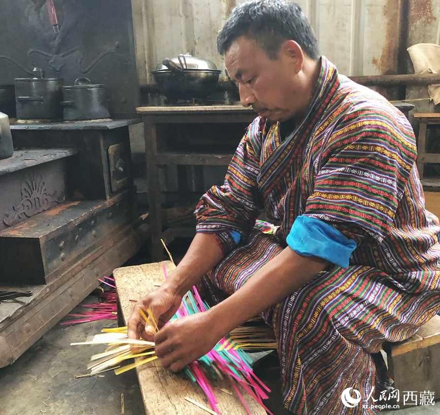 門巴族漢子愛明正在編織藤竹品。