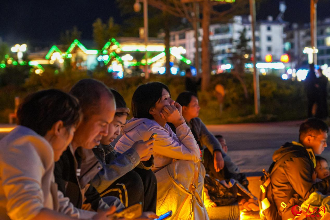 市民坐在西藏林芝市民族團結(jié)廣場臺階上欣賞音樂噴泉。人民網(wǎng)記者 趙晨攝