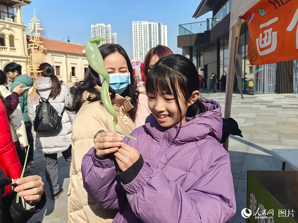 2025年1月29日，湖北武漢的新春廟會上，小朋友拿著吹制好的糖人，十分開心。人民網(wǎng)記者 張沛攝