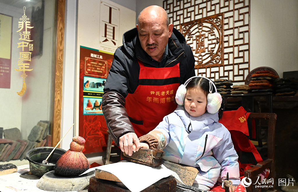 2025年1月27日，河南開封朱仙鎮(zhèn)木版年畫藝人尹國法指導小朋友研習年畫印制技藝。朱仙鎮(zhèn)木版年畫源自漢唐壁畫藝術，是中國木版年畫的鼻祖。2006年5月20日，朱仙鎮(zhèn)木版年畫經(jīng)國務院批準列入第一批國家級非物質(zhì)文化遺產(chǎn)名錄。人民網(wǎng)記者 王玉興攝