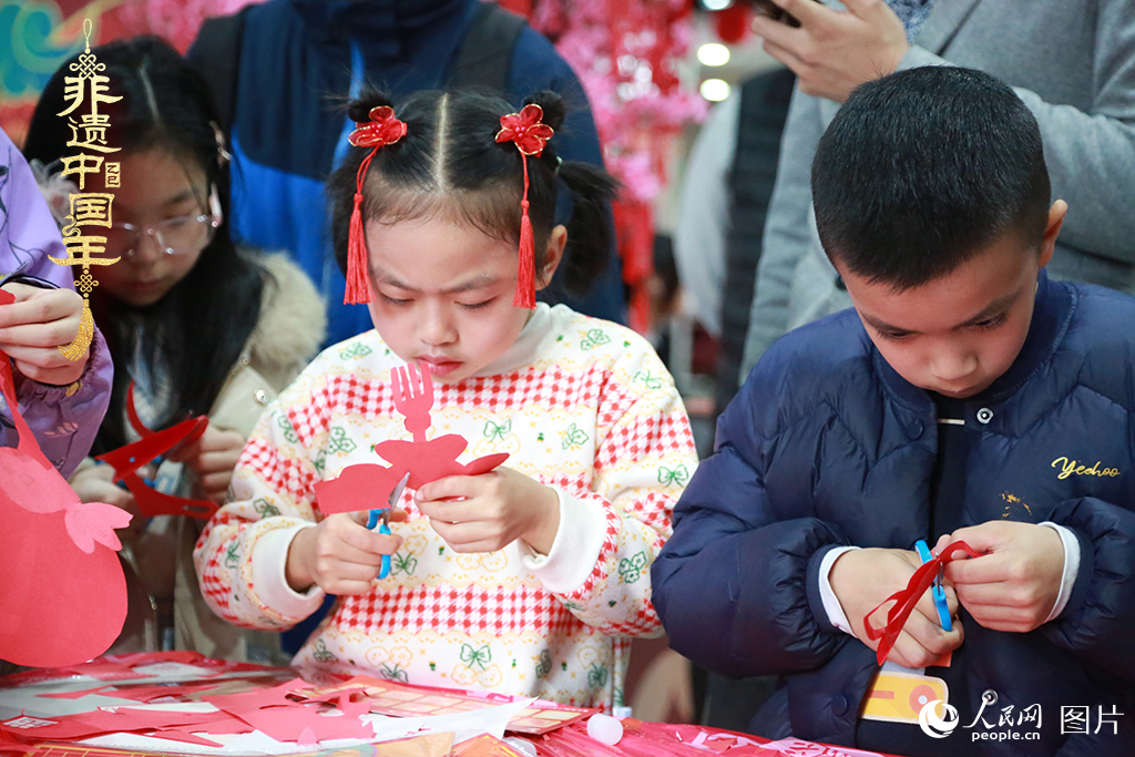 2025年1月23日，上海市青少年活動中心迎新春游園會上，小朋友們正在學習剪窗花。人民網(wǎng)記者 龔莎攝